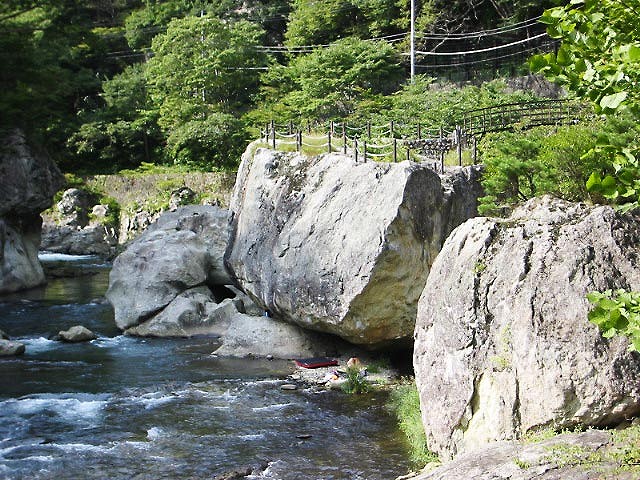 渓流を前にたたずむ巨大な姿