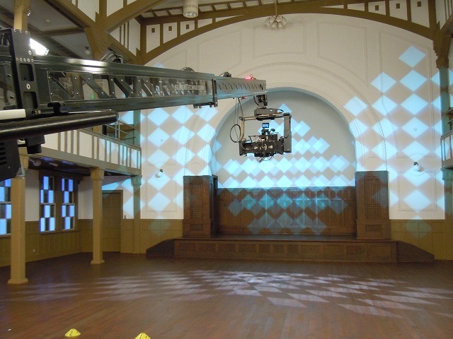 歌唱パートは峰ヶ丘講堂で撮影。照明によるチェック模様が印象的。